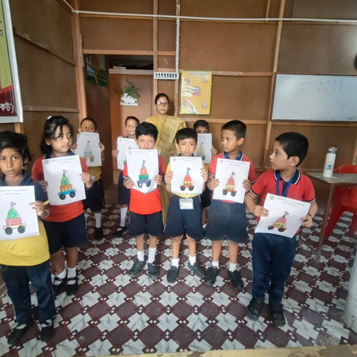 Children showing their craft work with their teacher at Shishu Tirtha School