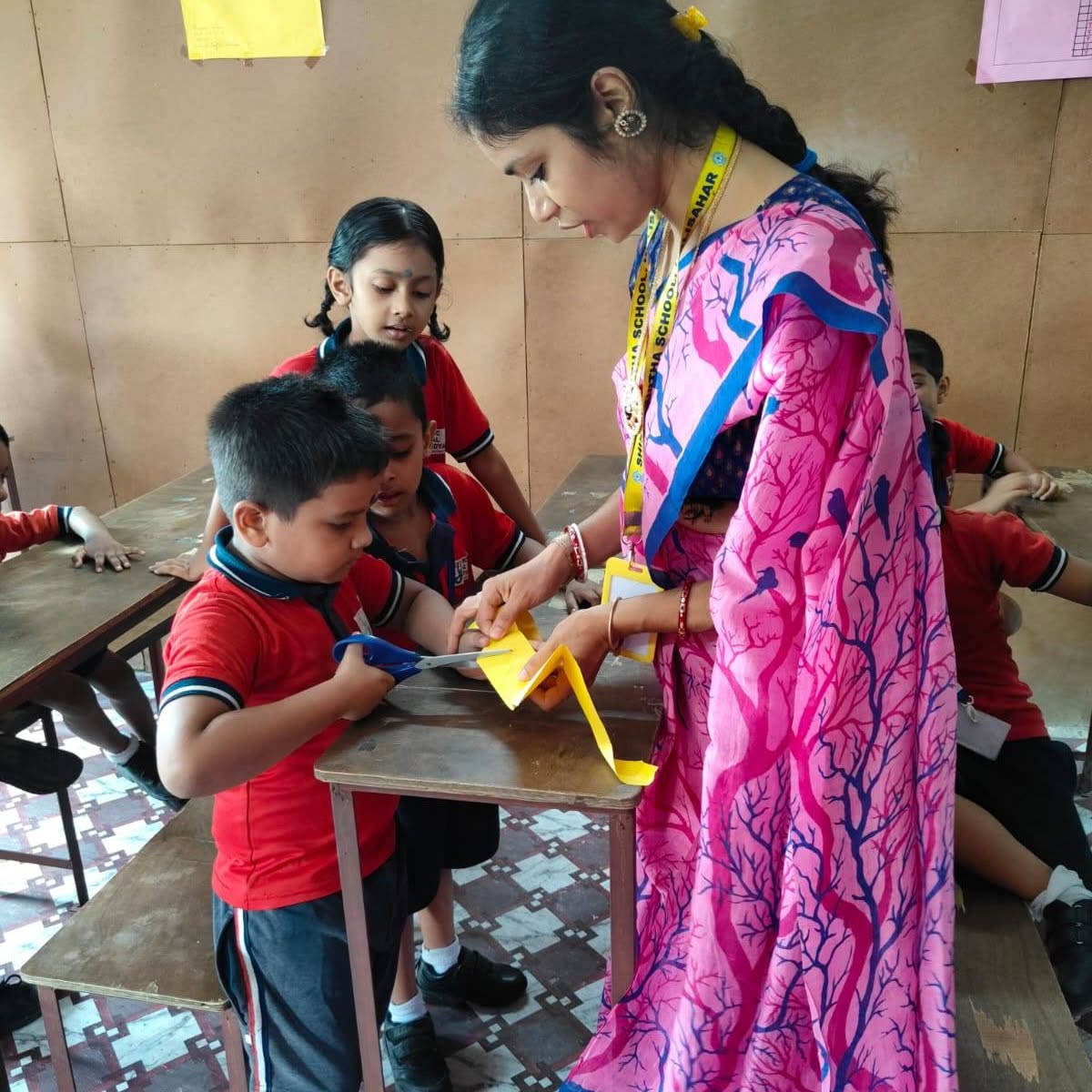Teacher helping a child with scissors during craft time