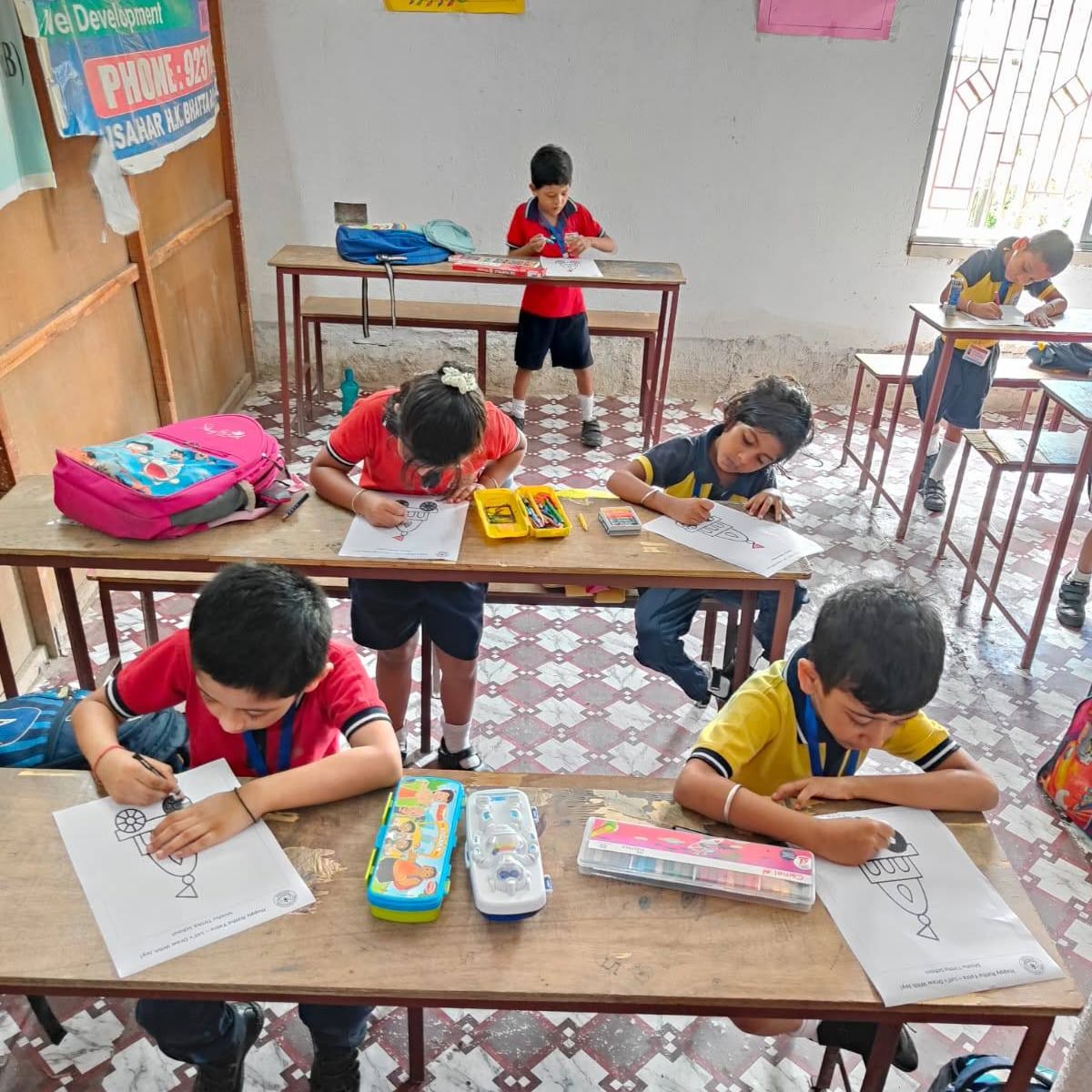 Children drawing at their classroom desks