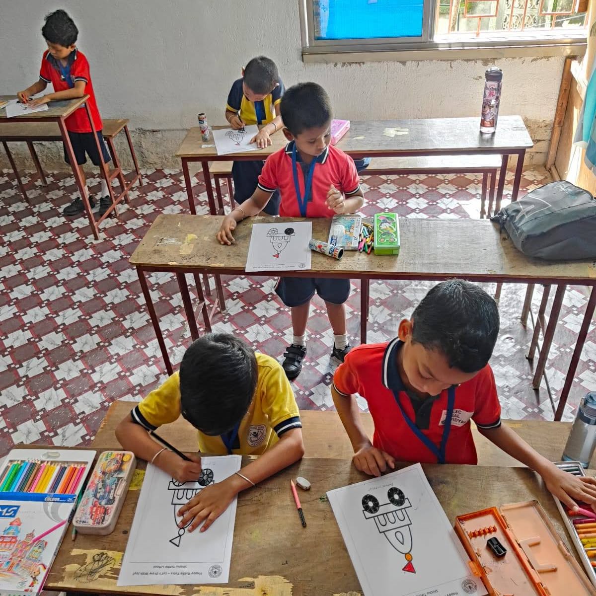 Children drawing at their classroom desks, another view