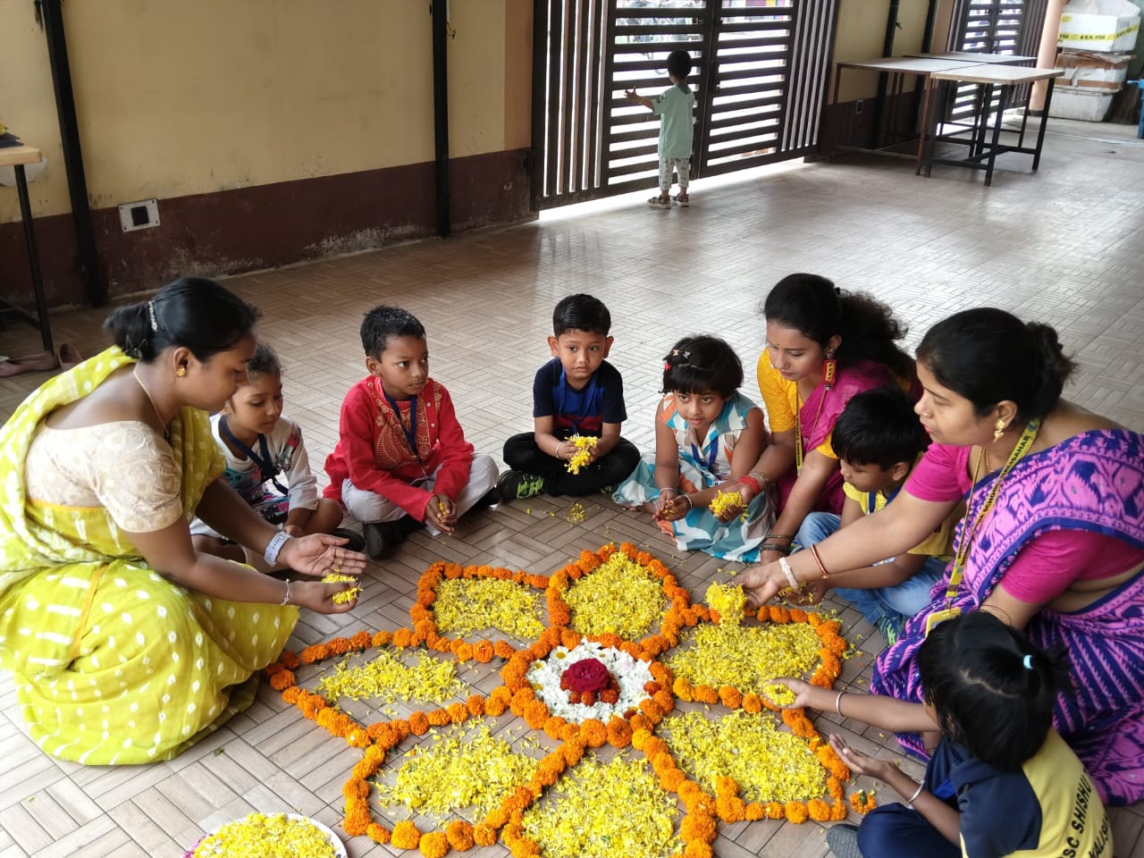 Students and teachers making rangoli with flowers