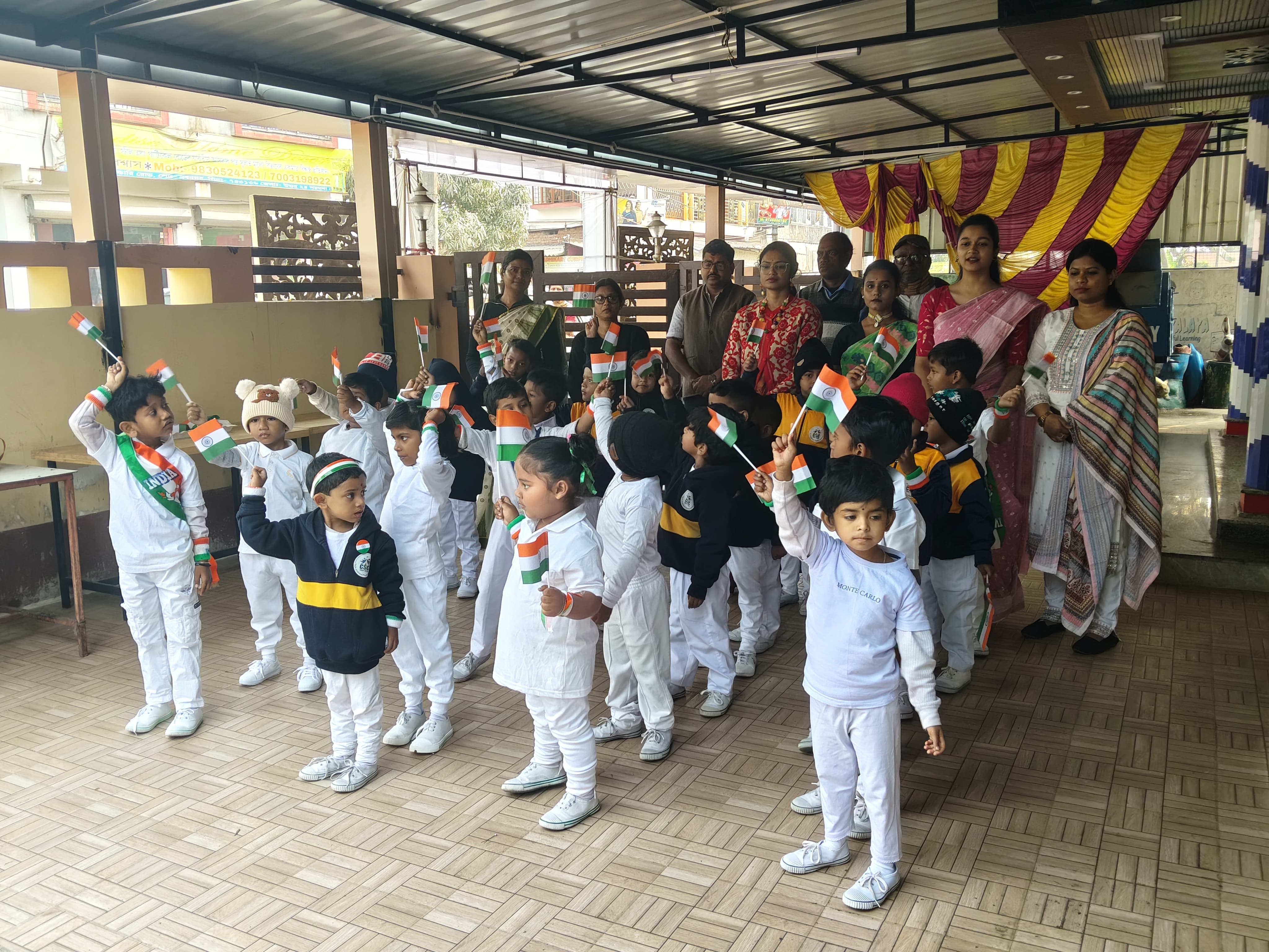 Students and teachers celebrating with the national flag on school premises